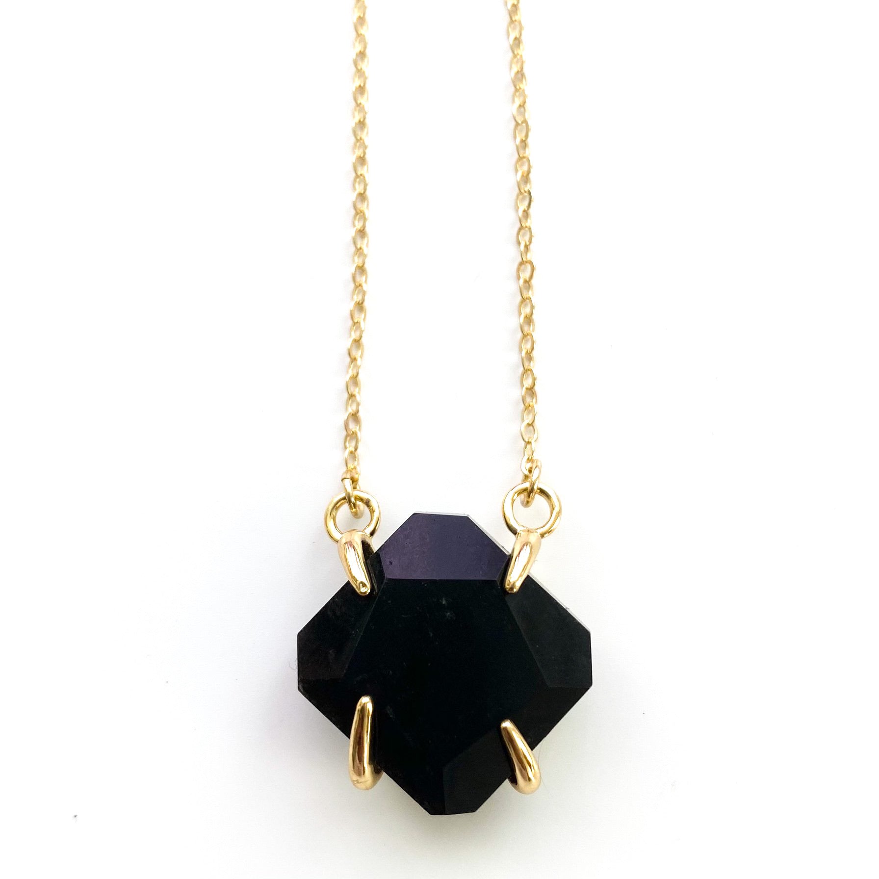 A beautiful handmade necklace featuring a clawed gemstone pendant on an 18K gold plated chain, showcasing elegance and spiritual significance.