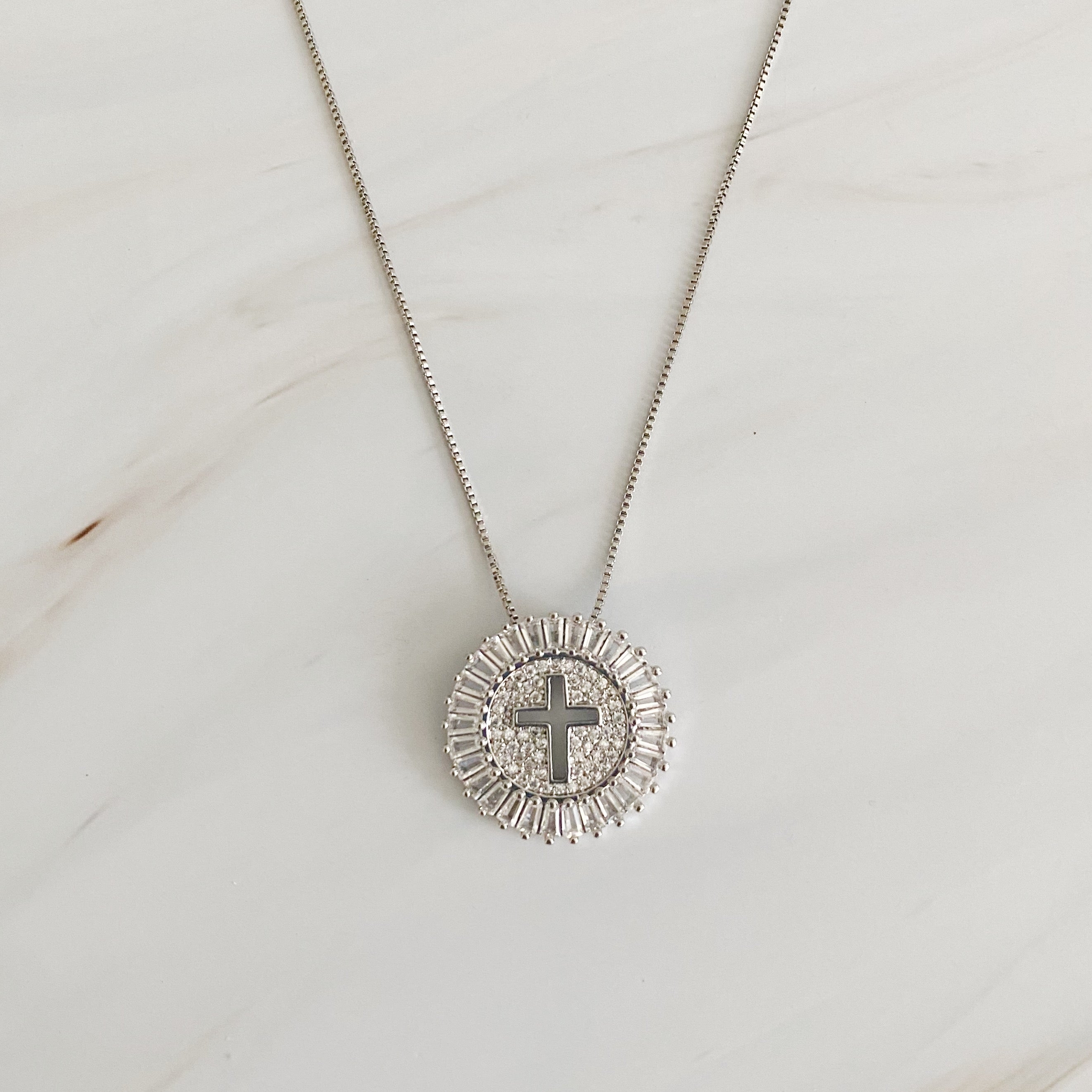 Shine Circle Cross Necklace featuring a sparkly round charm with a cut-out cross design, plated brass, and cubic zirconia.