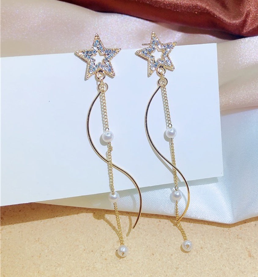 A pair of Shining Star earrings featuring elegant pearl tassels, crafted from durable alloy, showcasing a unique star design.