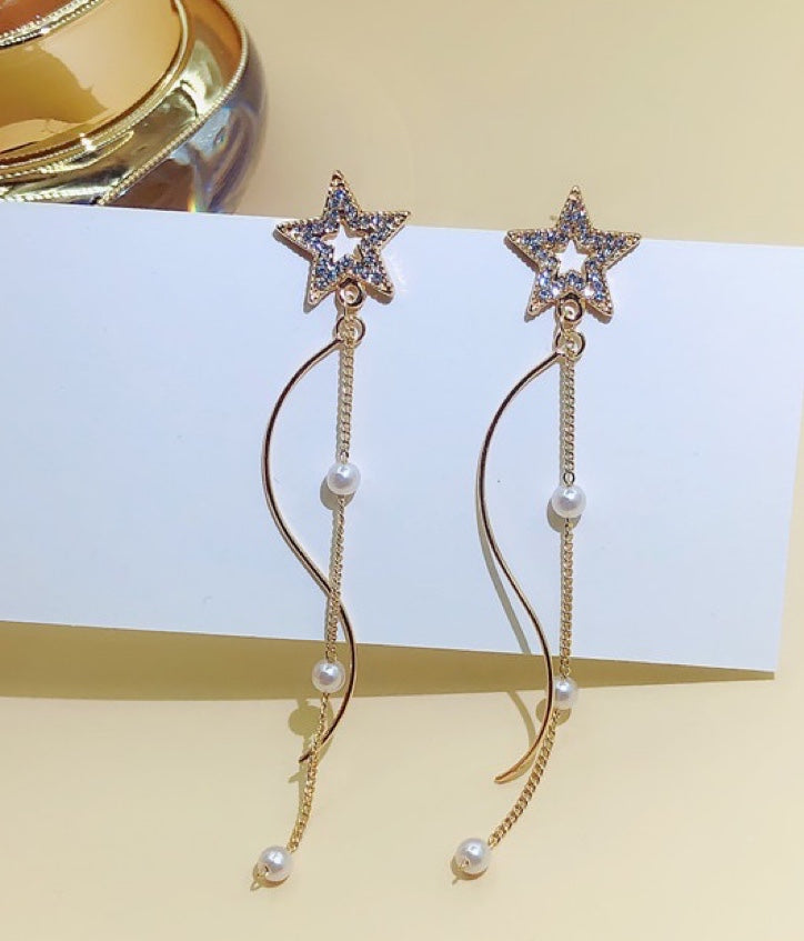 A pair of Shining Star earrings featuring elegant pearl tassels, crafted from durable alloy, showcasing a unique star design.