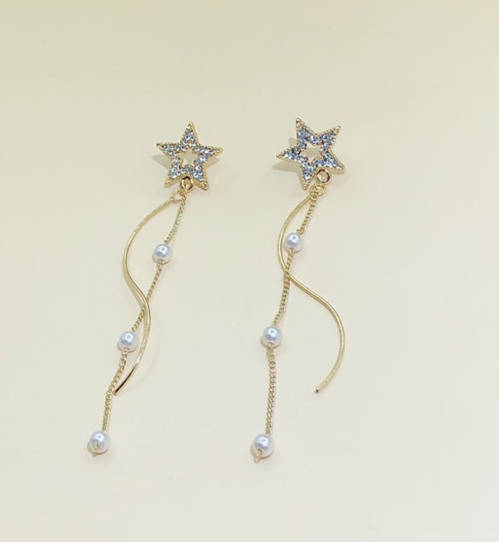 A pair of Shining Star earrings featuring elegant pearl tassels, crafted from durable alloy, showcasing a unique star design.