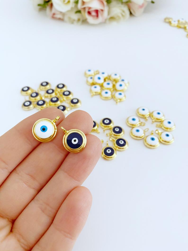 A collection of shiny gold evil eye beads, featuring blue and white designs, perfect for DIY jewelry making.