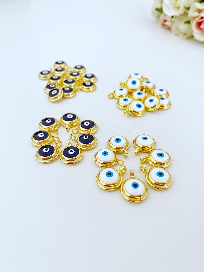 A collection of shiny gold evil eye beads, featuring blue and white designs, perfect for DIY jewelry making.