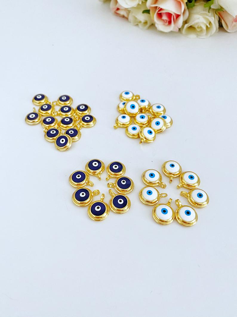 A collection of shiny gold evil eye beads, featuring blue and white designs, perfect for DIY jewelry making.