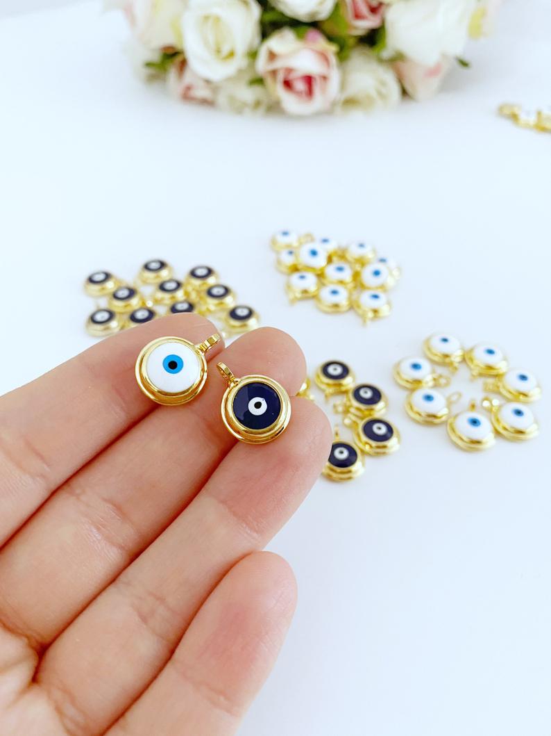 A collection of shiny gold evil eye beads, featuring blue and white designs, perfect for DIY jewelry making.