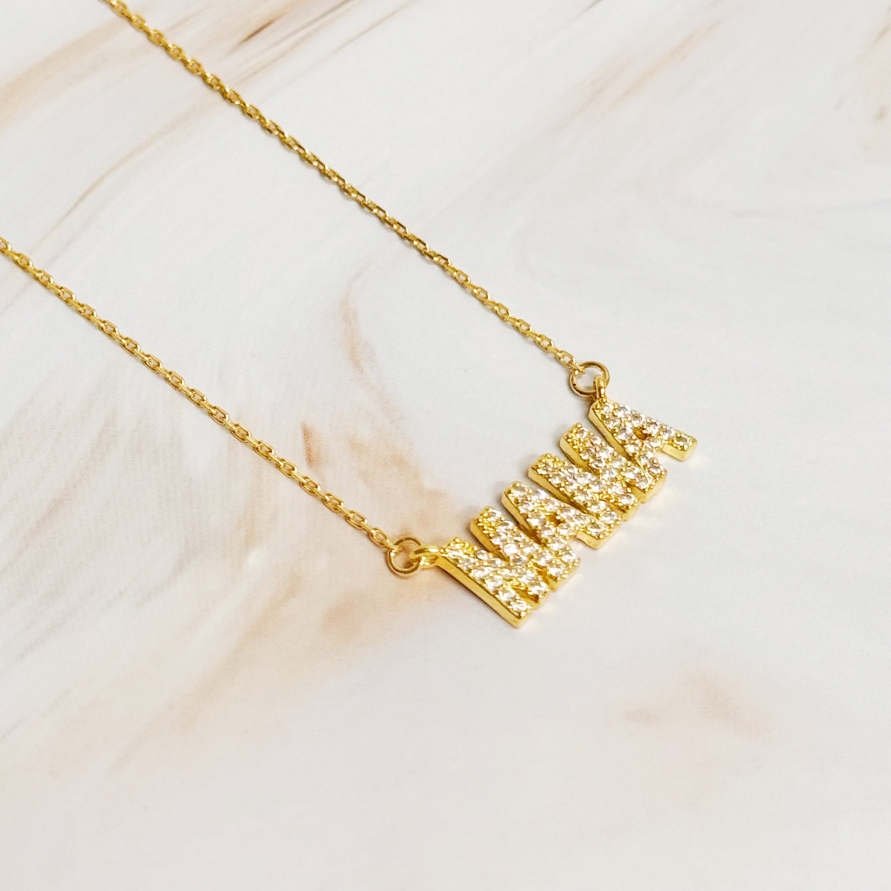 Shiny Mama Necklace featuring a clean font design with sparkling cubic zirconia stones on an 18k gold plated brass chain.