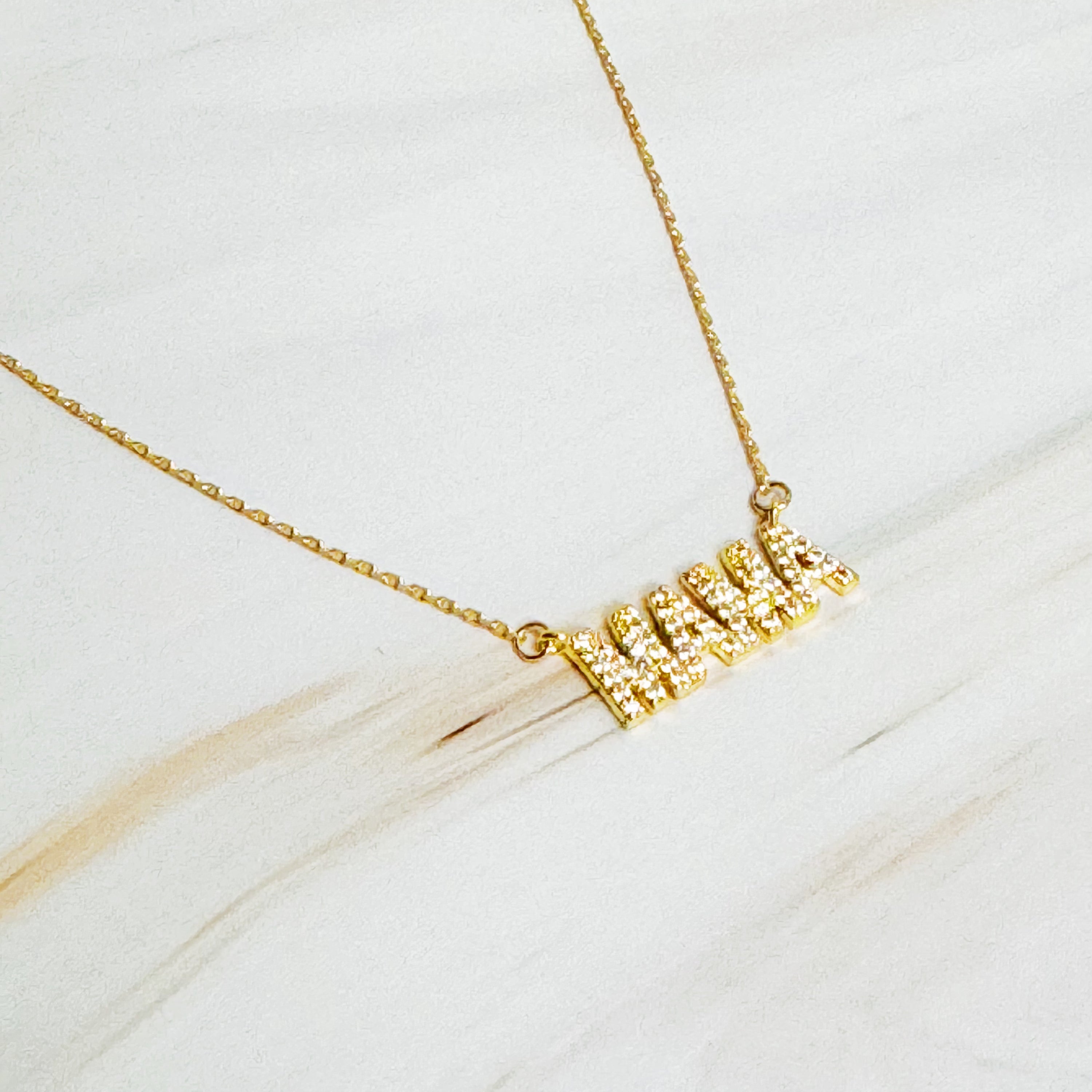 Shiny Mama Necklace featuring a clean font design with sparkling cubic zirconia stones on an 18k gold plated brass chain.