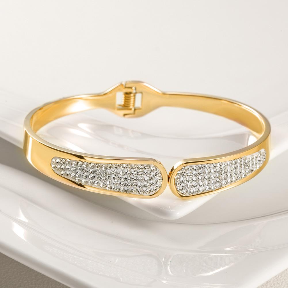 A shiny PAVÉ bangle bracelet made of stainless steel with 14K gold plating, featuring a luxurious pavé design.