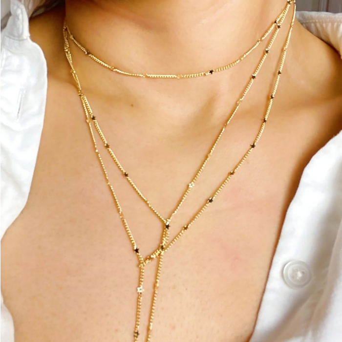 Show Me The Ways Necklace in Gold featuring tiny stars on a long linked chain, showcasing its elegant design and versatility.