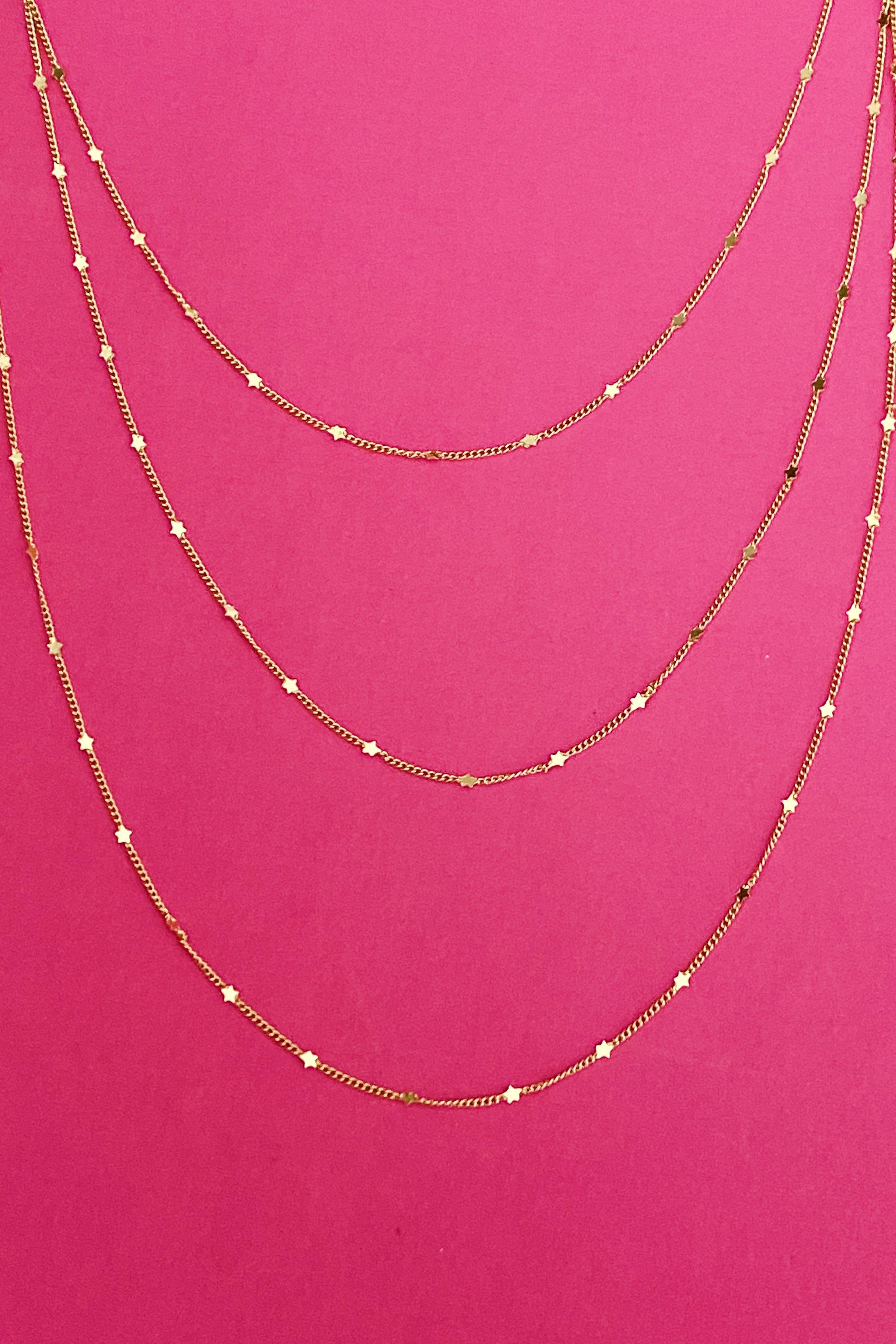 Show Me The Ways Necklace in Gold featuring tiny stars on a long linked chain, showcasing its elegant design and versatility.