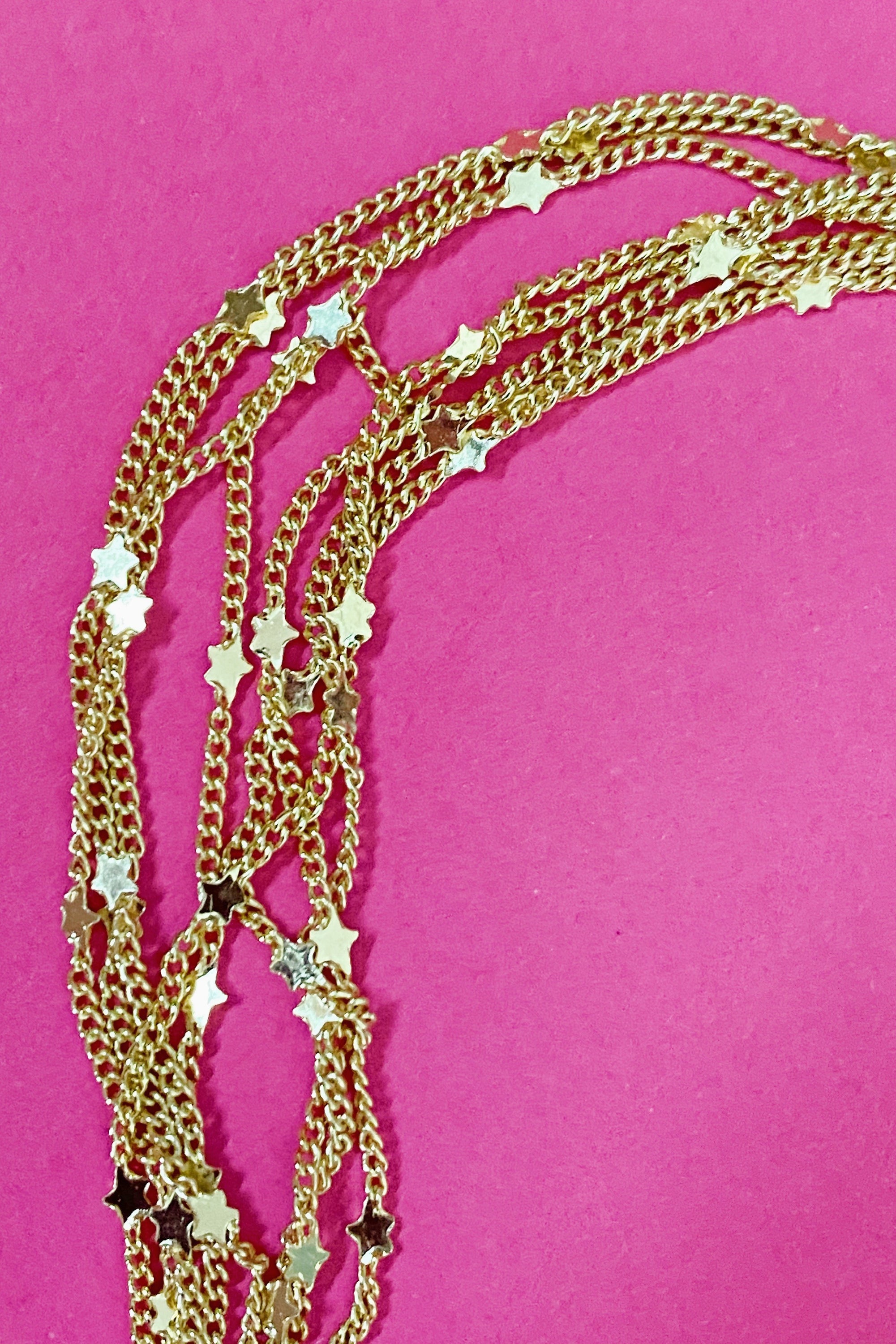 Show Me The Ways Necklace in Gold featuring tiny stars on a long linked chain, showcasing its elegant design and versatility.