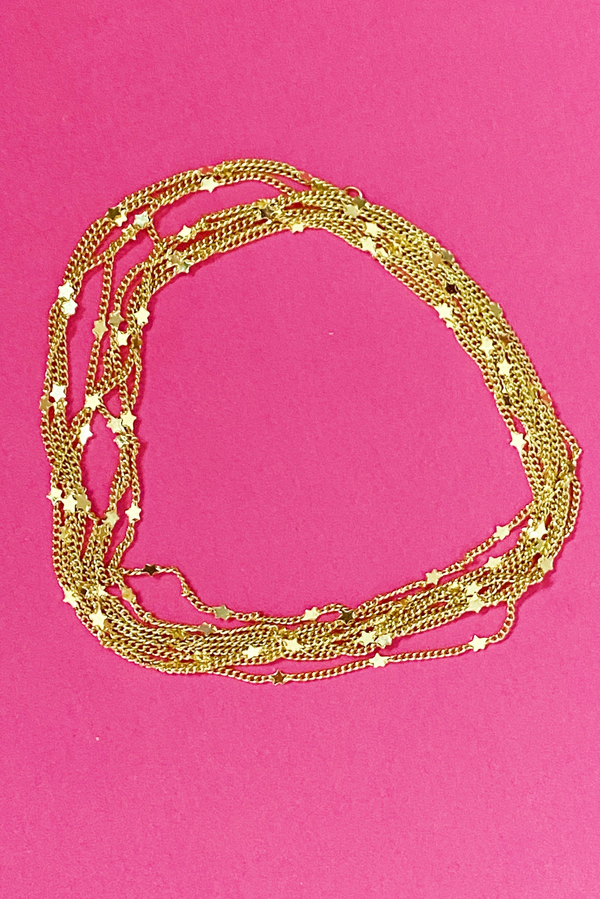 Show Me The Ways Necklace in Gold featuring tiny stars on a long linked chain, showcasing its elegant design and versatility.