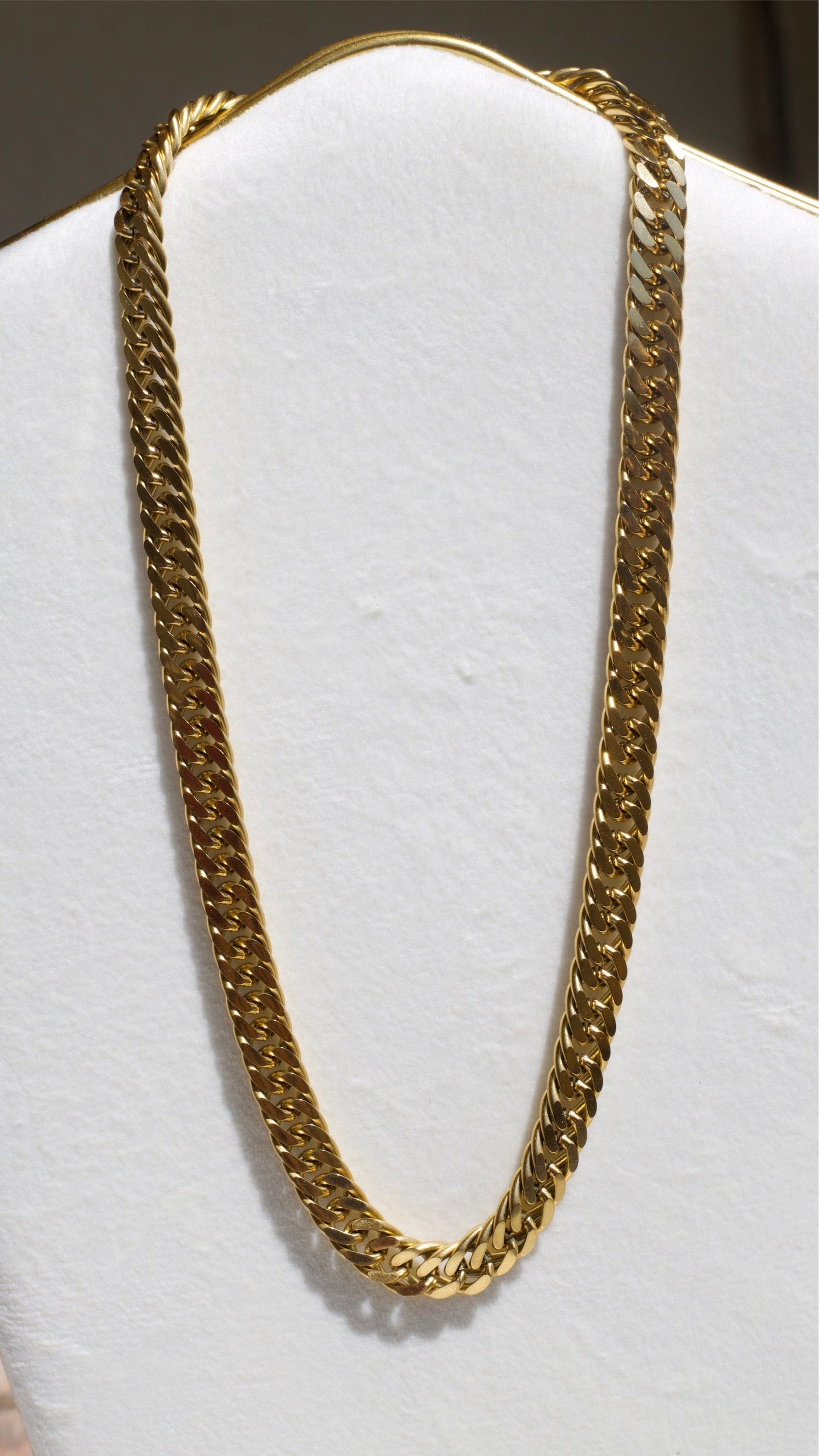 Sienna Cuban Chain Necklace in Gold, featuring a 9mm width and luxurious 18K gold PVD plating, displayed elegantly.