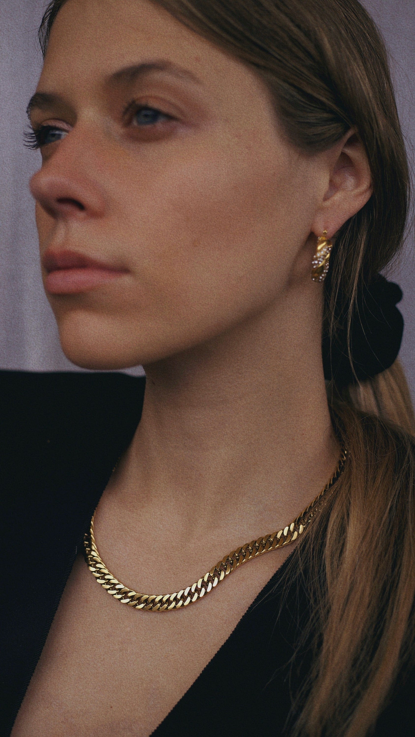 Sienna Cuban Chain Necklace in Gold, featuring a 9mm width and luxurious 18K gold PVD plating, displayed elegantly.