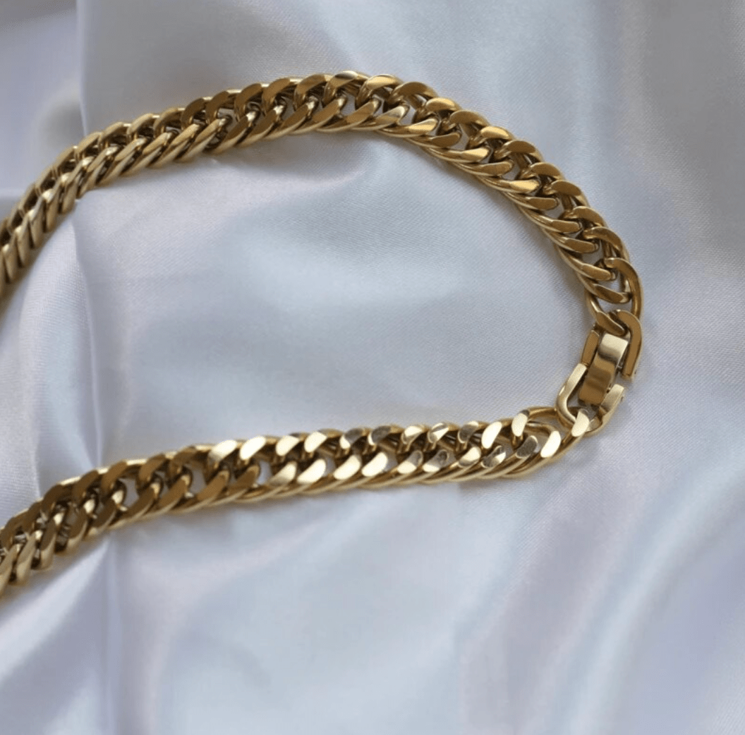 Sienna Cuban Chain Necklace in Gold, featuring a 9mm width and luxurious 18K gold PVD plating, displayed elegantly.