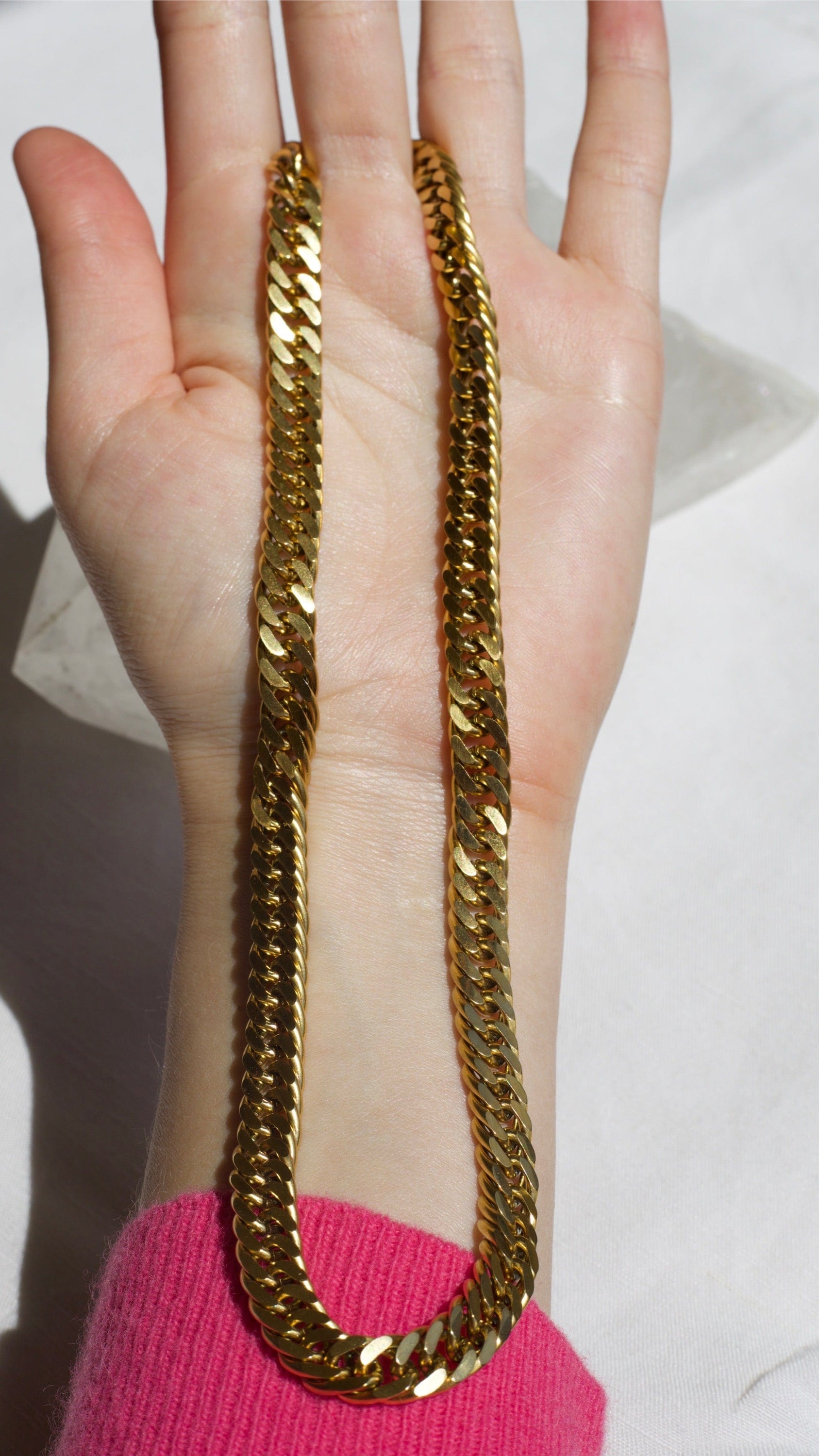 Sienna Cuban Chain Necklace in Gold, featuring a 9mm width and luxurious 18K gold PVD plating, displayed elegantly.