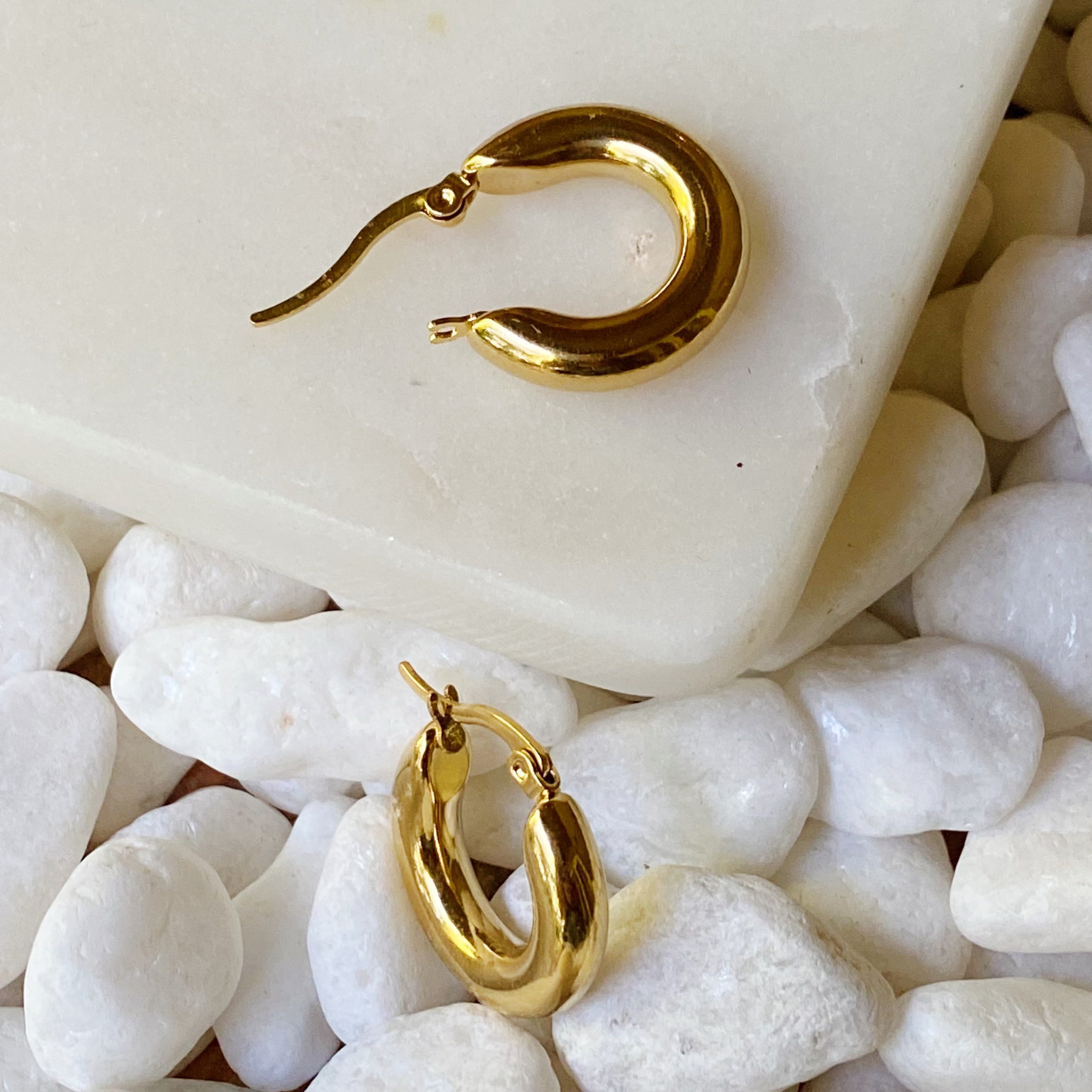 Sienna Huggie Hoop Earrings in polished gold finish, showcasing their small size and elegant design.