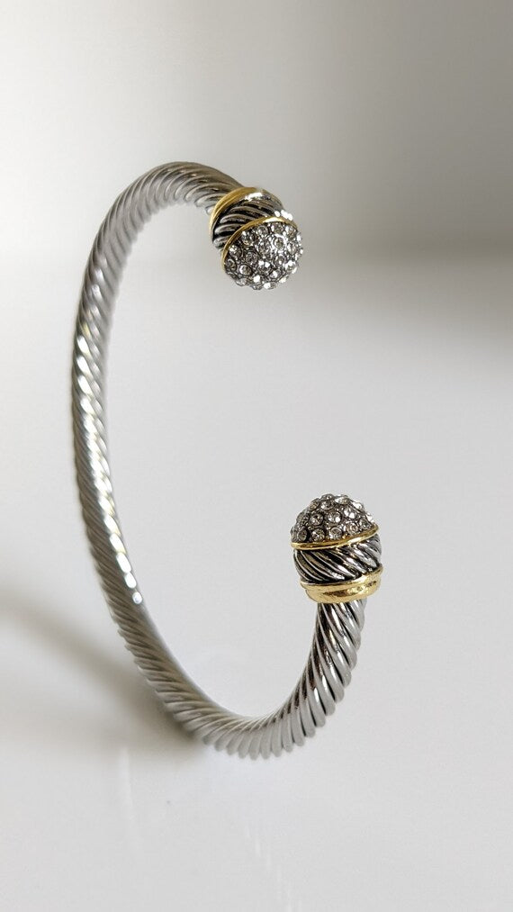 Elegant silver bangle bracelet adorned with simulated diamond accents, showcasing a textured finish and substantial design.