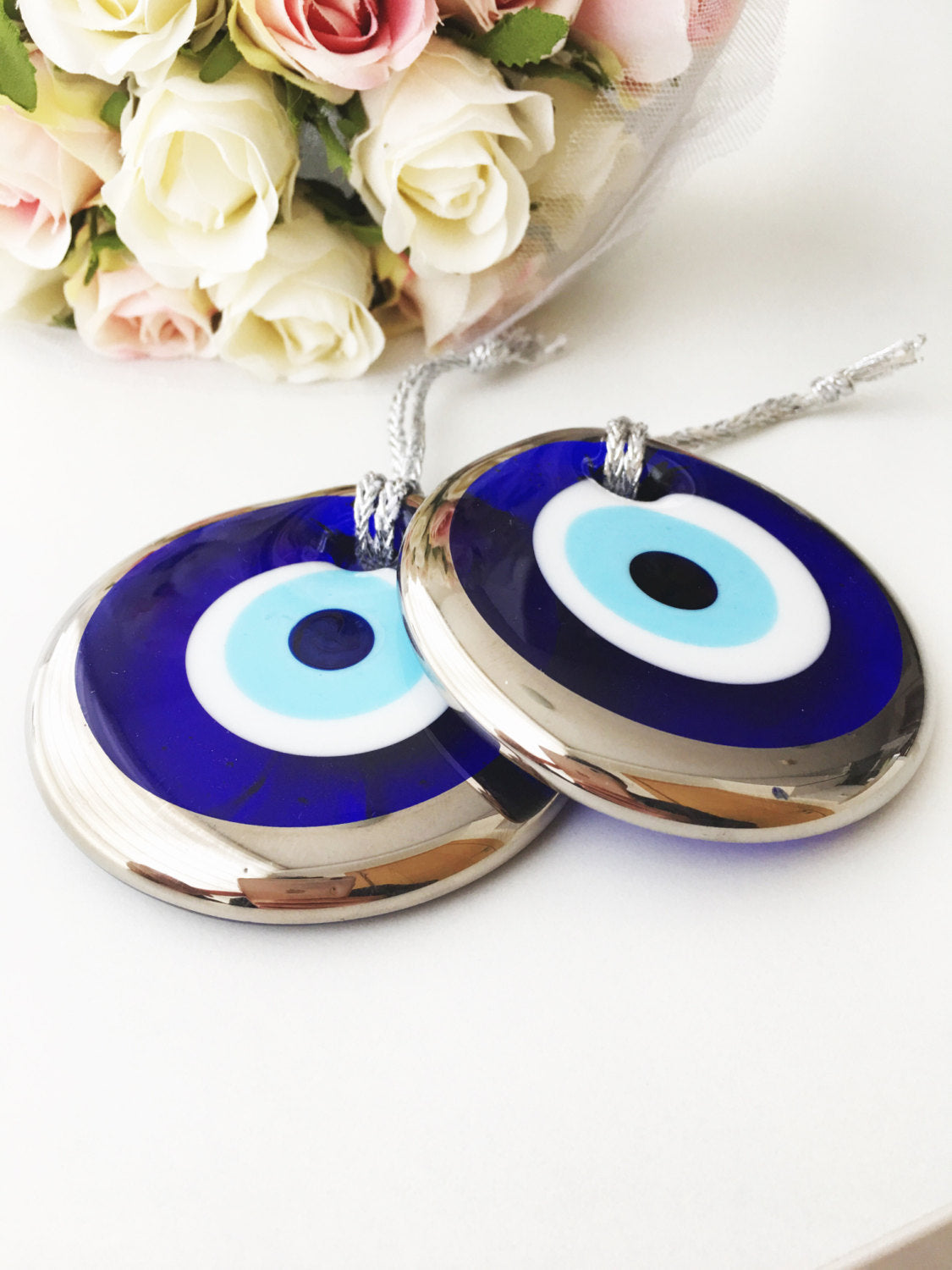 A 7cm silver evil eye bead wall hanging with intricate designs, featuring a silver rope for easy hanging, symbolizing protection and good luck.