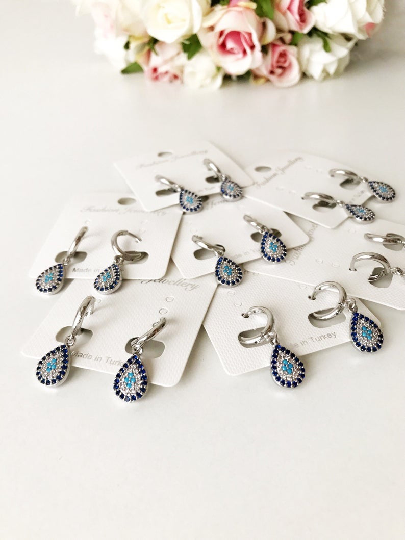 A pair of handcrafted silver evil eye hoop earrings featuring zirconia accents, showcasing a small hoop design.