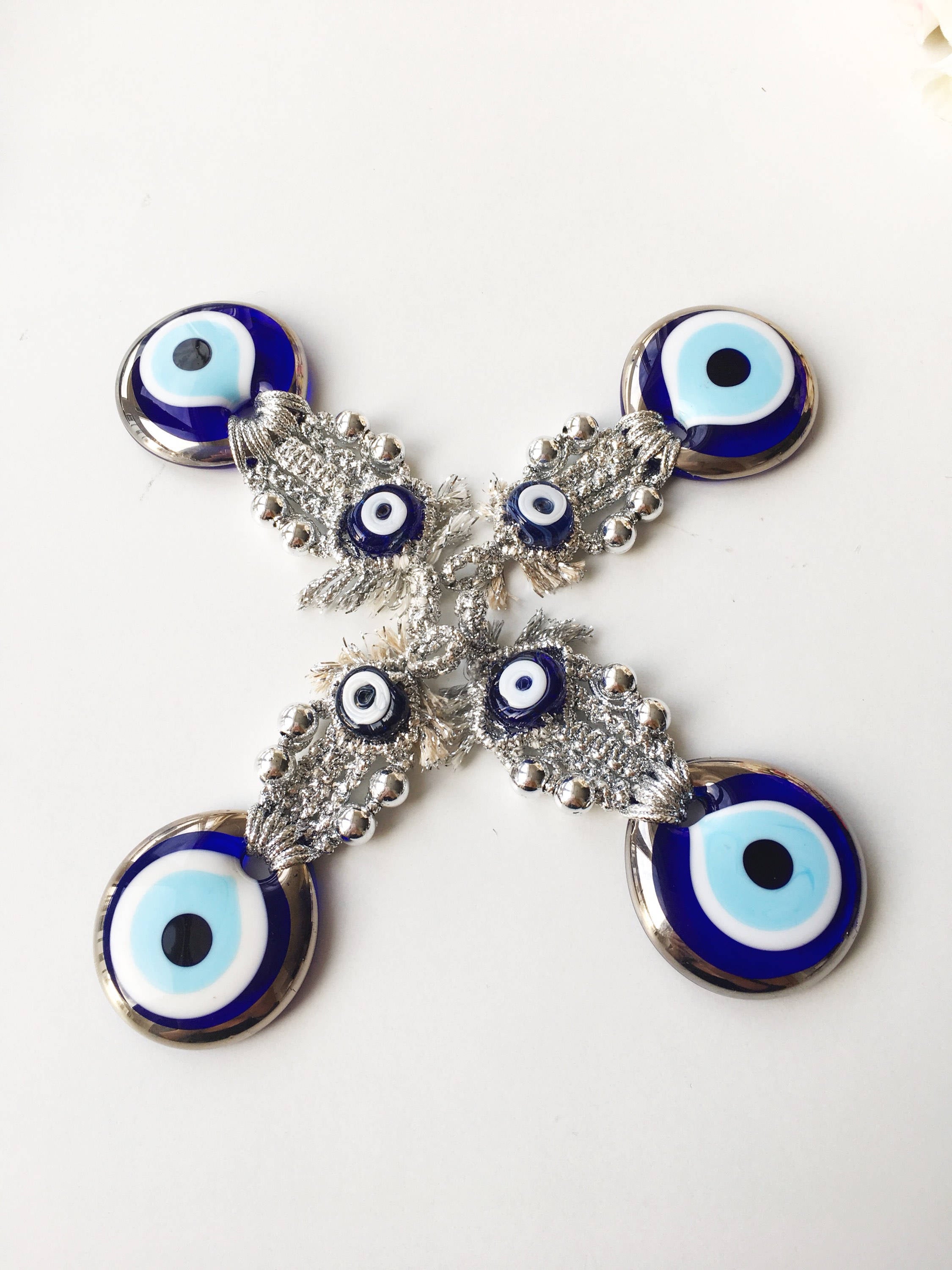 A handmade Silver Evil Eye Macrame Wall Hanging featuring a 4.5cm evil eye bead, crafted with silver macrame rope and gold accents.