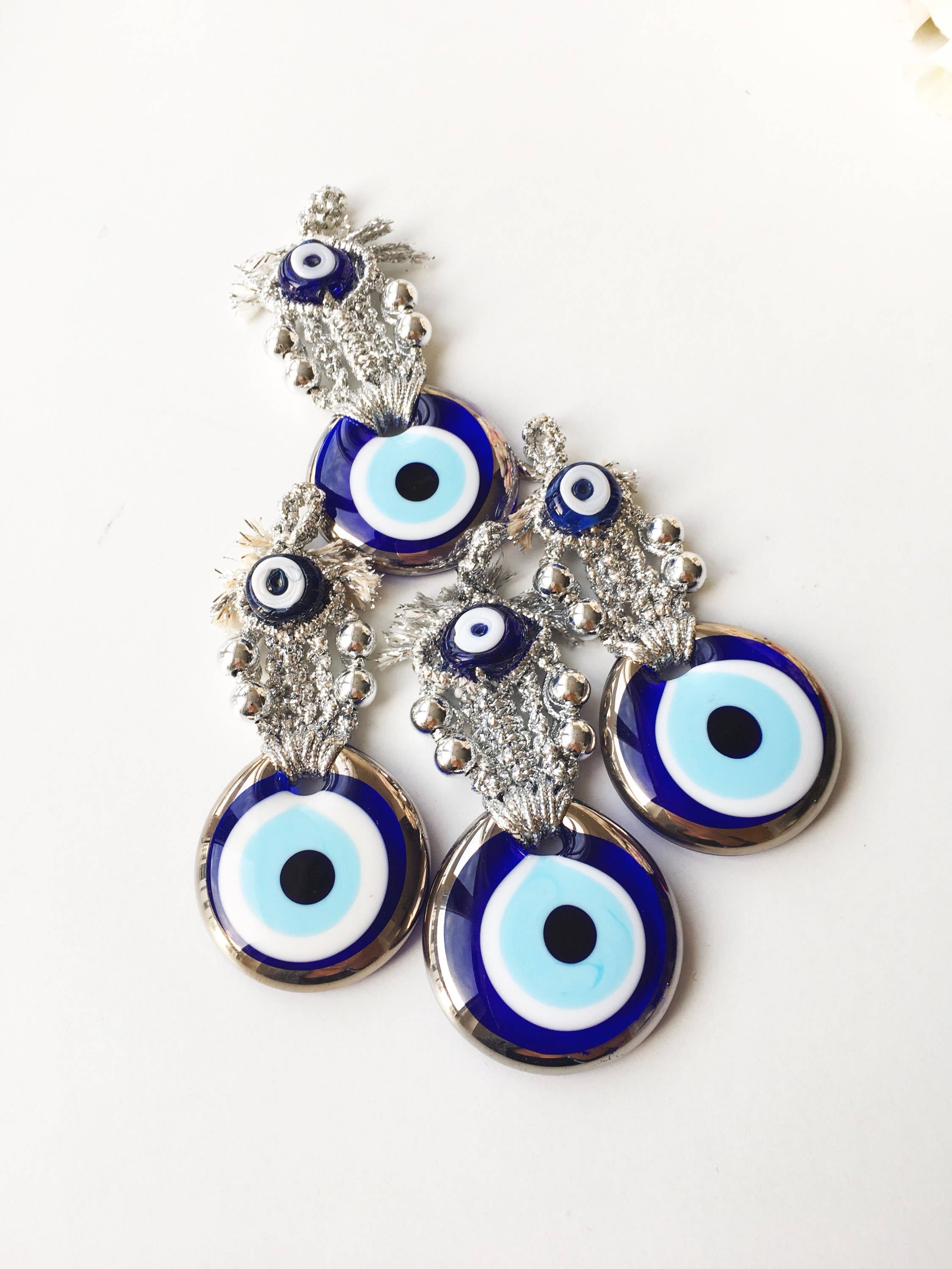 A handmade Silver Evil Eye Macrame Wall Hanging featuring a 4.5cm evil eye bead, crafted with silver macrame rope and gold accents.