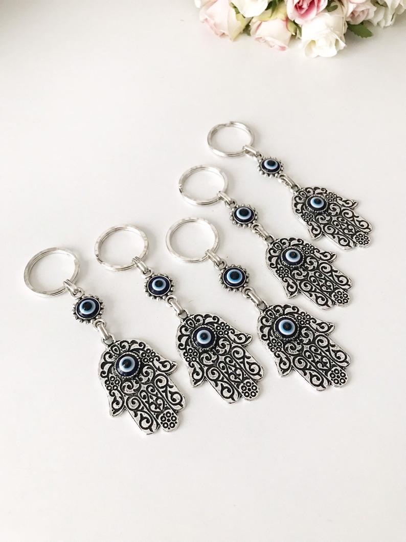 A beautiful silver hamsa keyring featuring handmade blue glass evil eye beads, symbolizing protection and good luck.