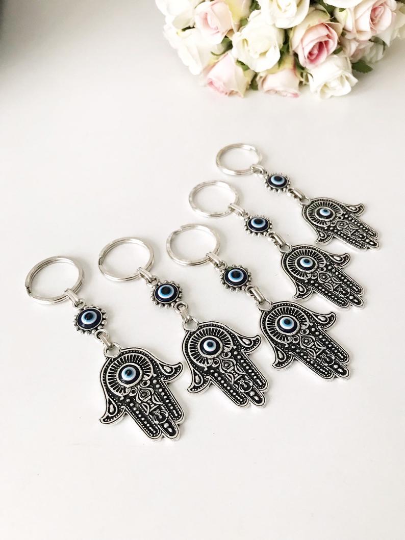 A beautiful silver hamsa keyring featuring handmade blue glass evil eye beads, symbolizing protection and good luck.