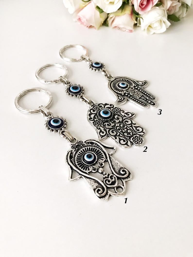 A beautiful silver hamsa keyring featuring handmade blue glass evil eye beads, symbolizing protection and good luck.