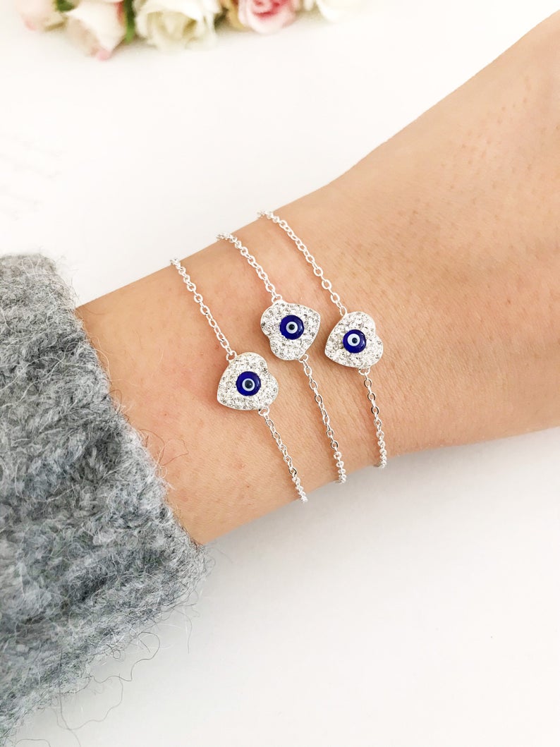 A delicate silver heart bracelet featuring an evil eye charm, elegantly designed for protection and style.