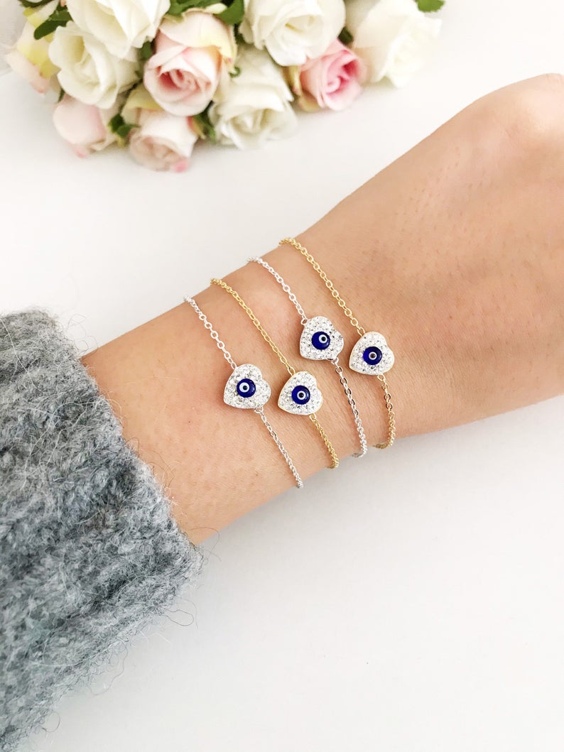 A delicate silver heart bracelet featuring an evil eye charm, elegantly designed for protection and style.