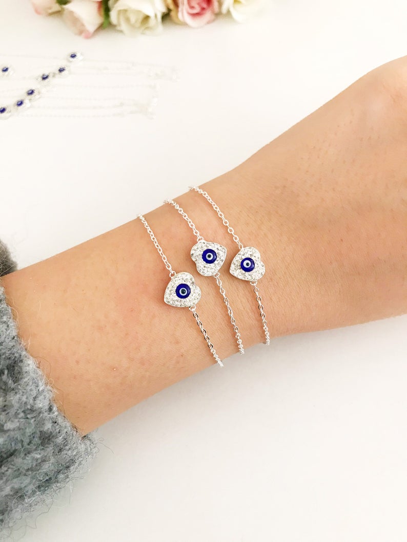 A delicate silver heart bracelet featuring an evil eye charm, elegantly designed for protection and style.