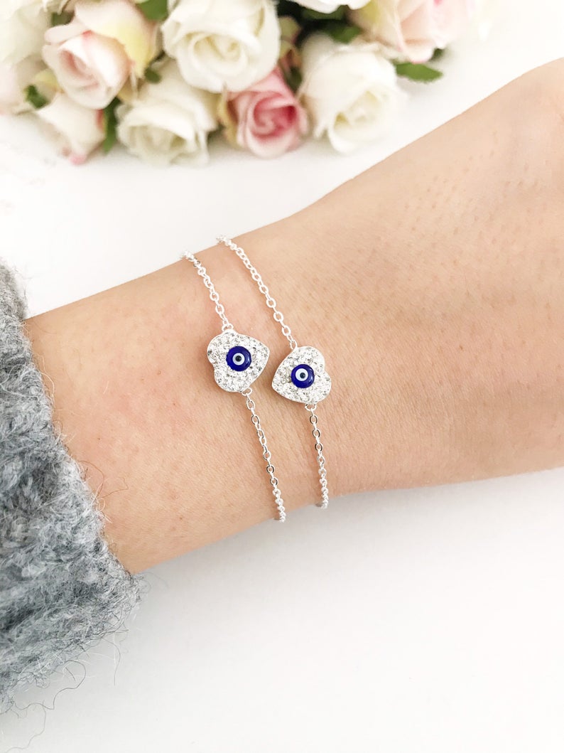 A delicate silver heart bracelet featuring an evil eye charm, elegantly designed for protection and style.