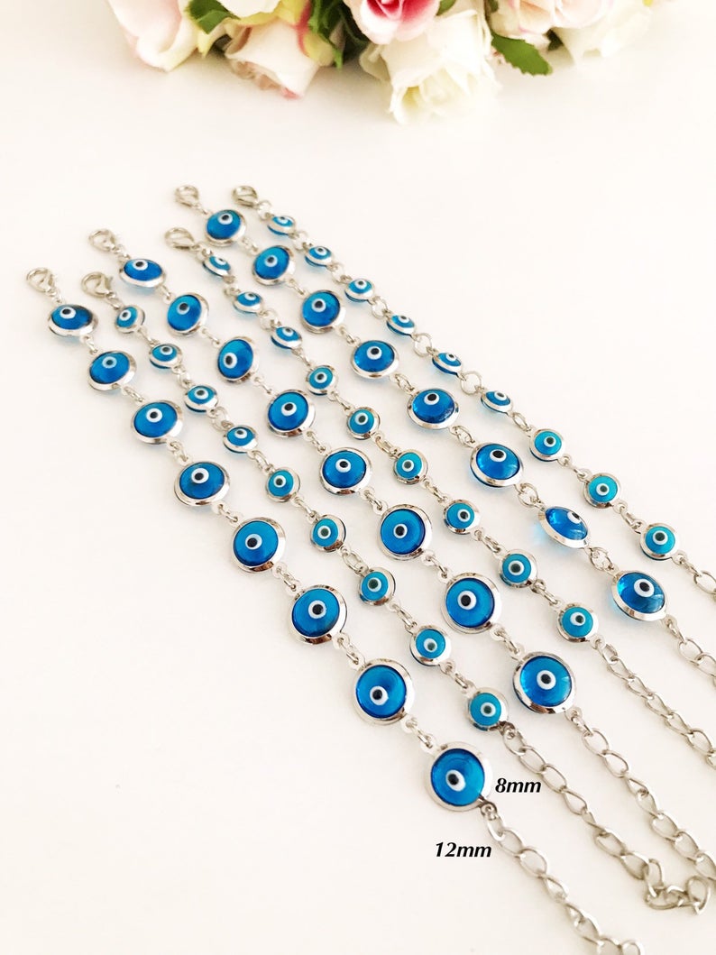 Silver link chain bracelet adorned with clear turquoise evil eye beads, showcasing a blend of elegance and cultural significance.