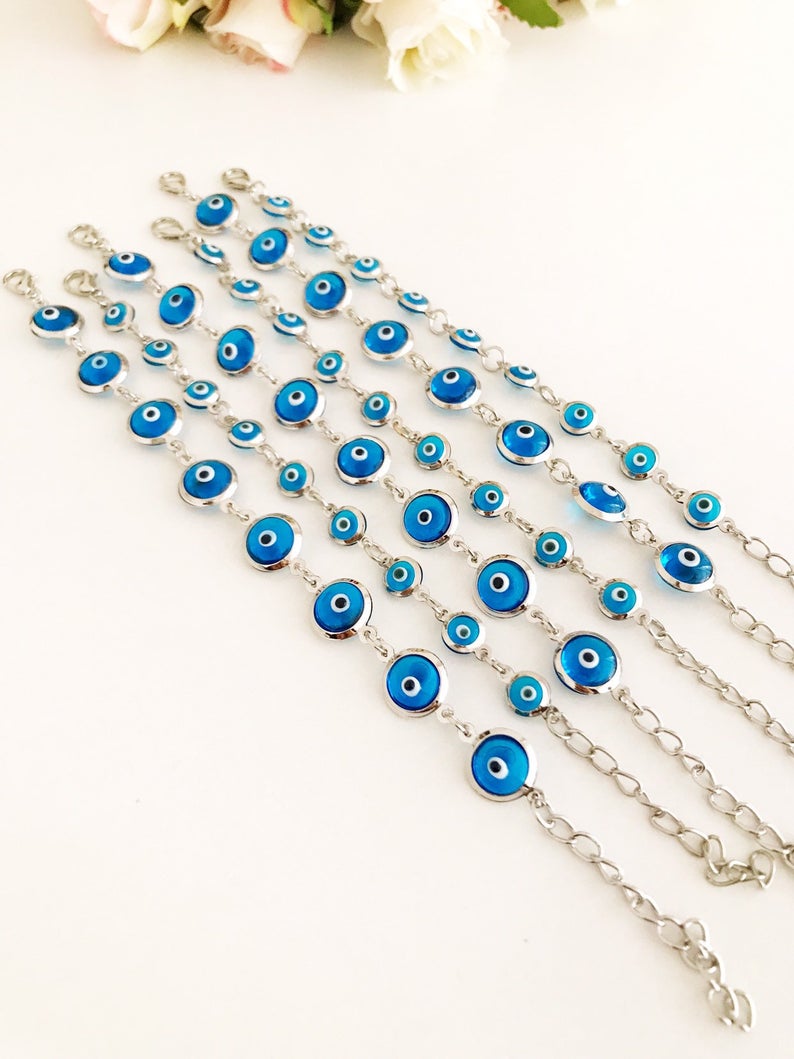 Silver link chain bracelet adorned with clear turquoise evil eye beads, showcasing a blend of elegance and cultural significance.