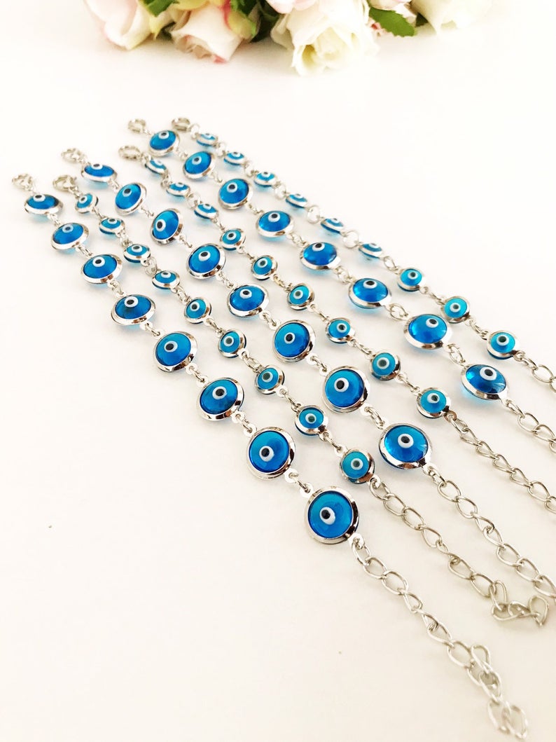 Silver link chain bracelet adorned with clear turquoise evil eye beads, showcasing a blend of elegance and cultural significance.