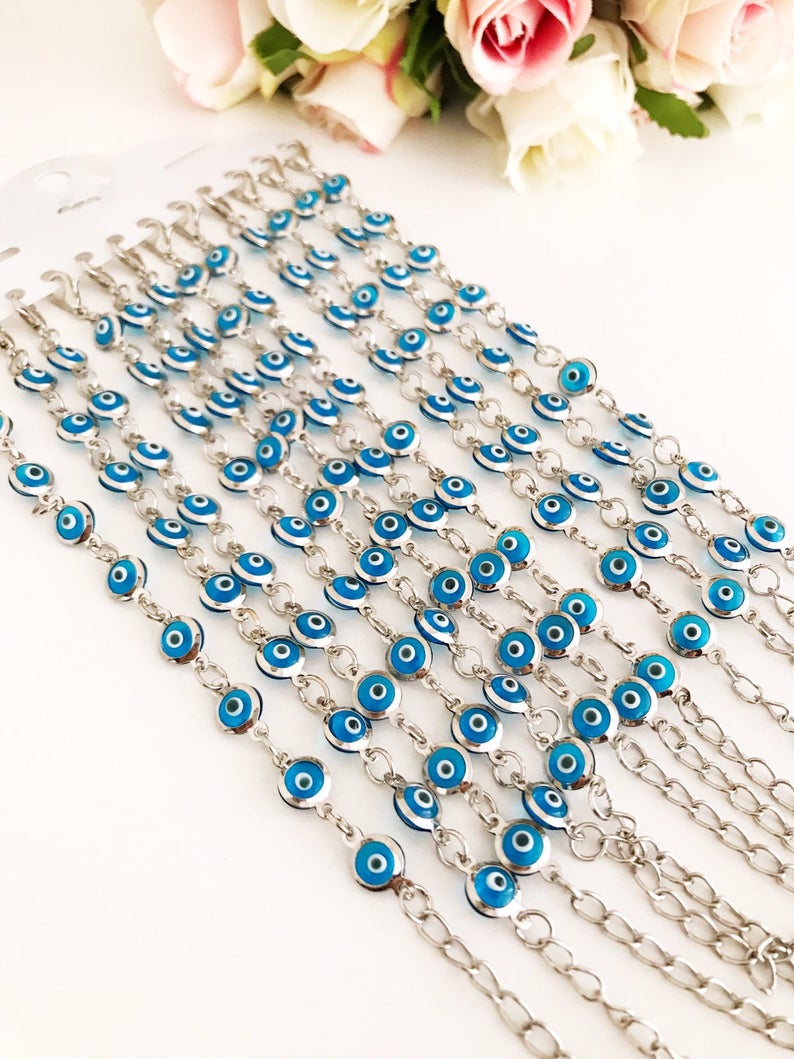 Silver link chain bracelet adorned with clear turquoise evil eye beads, showcasing a blend of elegance and cultural significance.