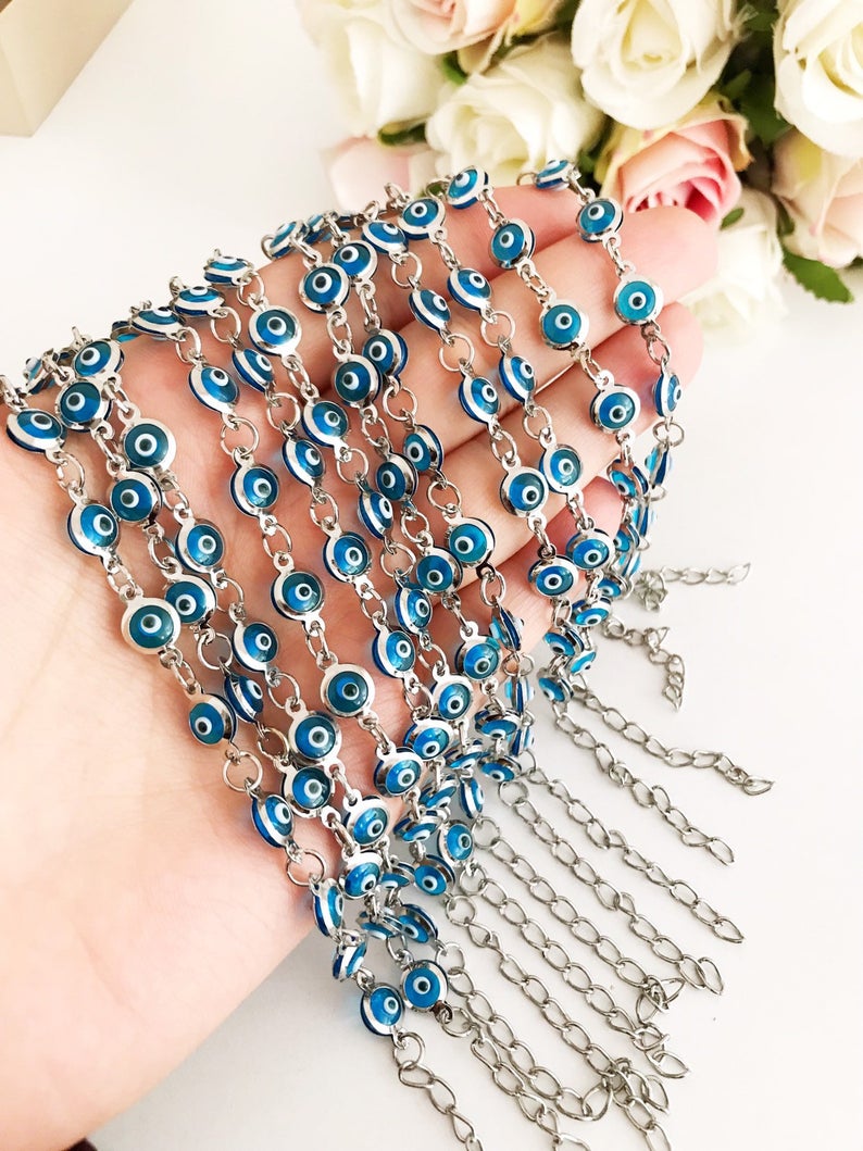 Silver link chain bracelet adorned with clear turquoise evil eye beads, showcasing a blend of elegance and cultural significance.