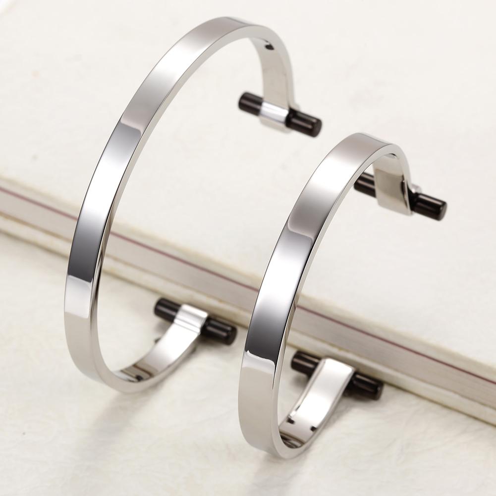 A pair of elegant Silver Love Couple Cuffs made from surgical stainless steel with 14K gold PVD plating, showcasing a modern design.