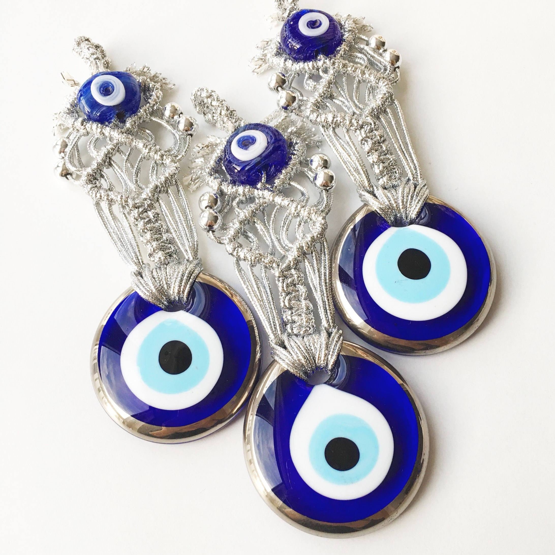 Silver Macrame Evil Eye Charm wall hanging with intricate design and blue evil eye bead.