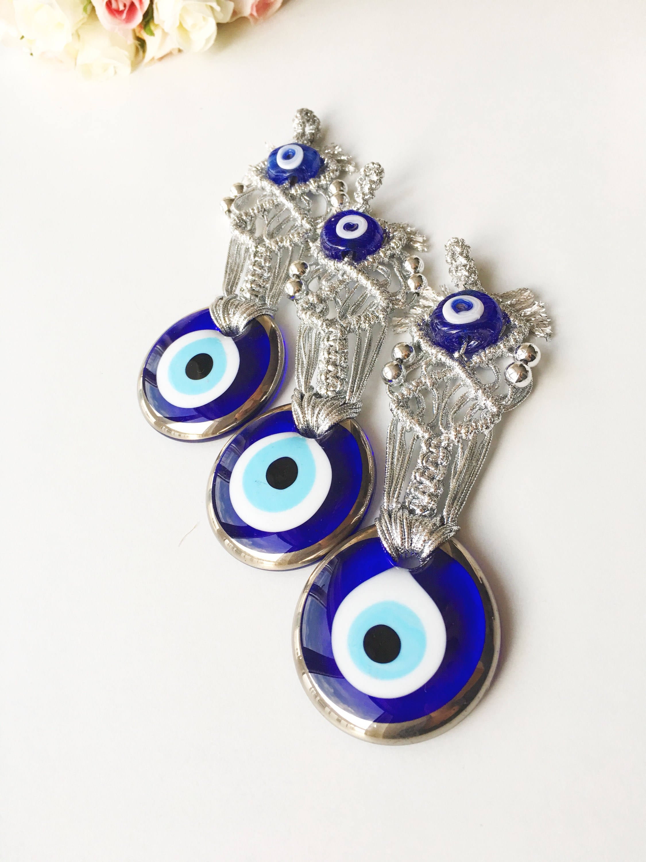 Silver Macrame Evil Eye Charm wall hanging with intricate design and blue evil eye bead.