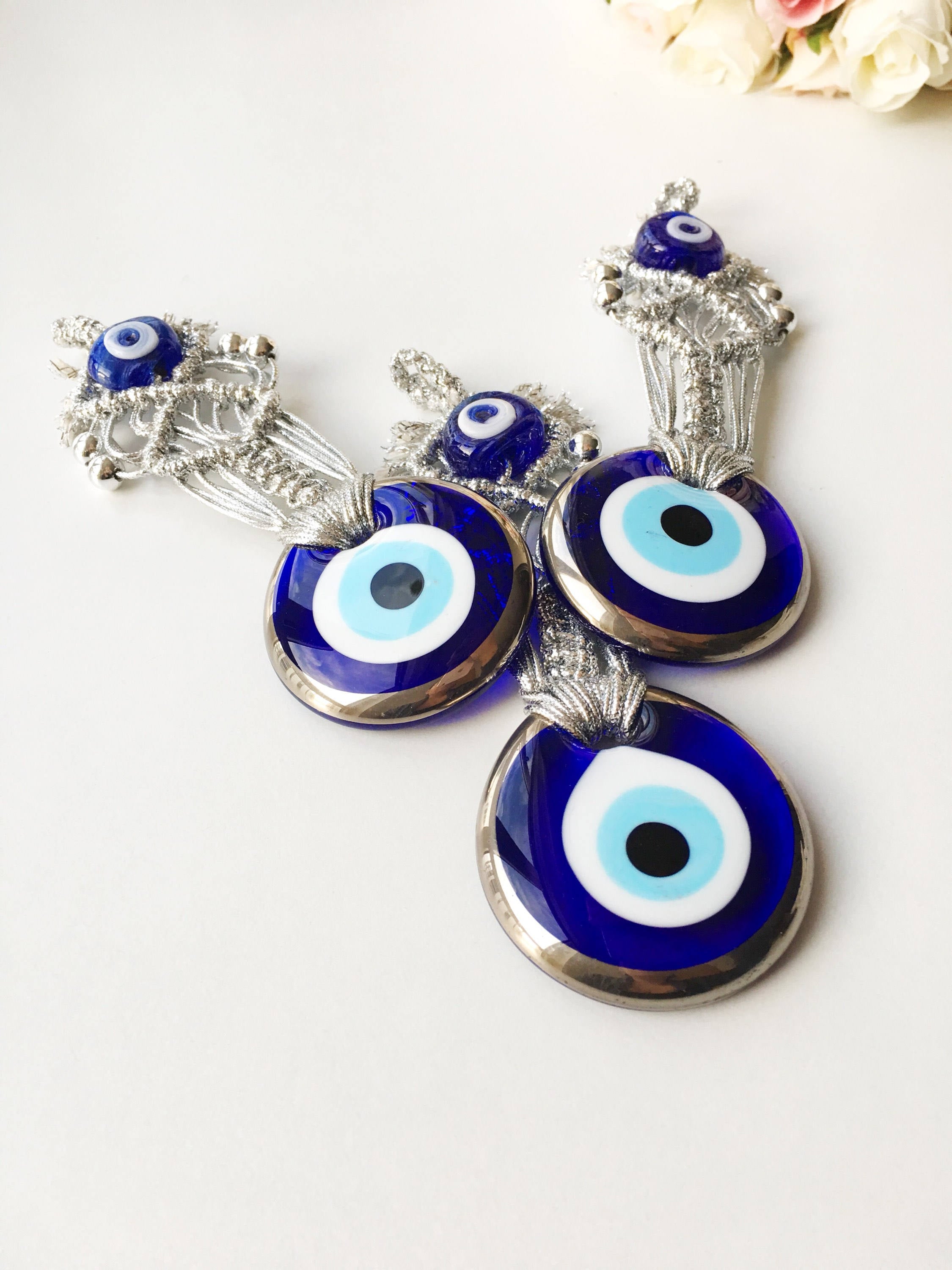 Silver Macrame Evil Eye Charm wall hanging with intricate design and blue evil eye bead.