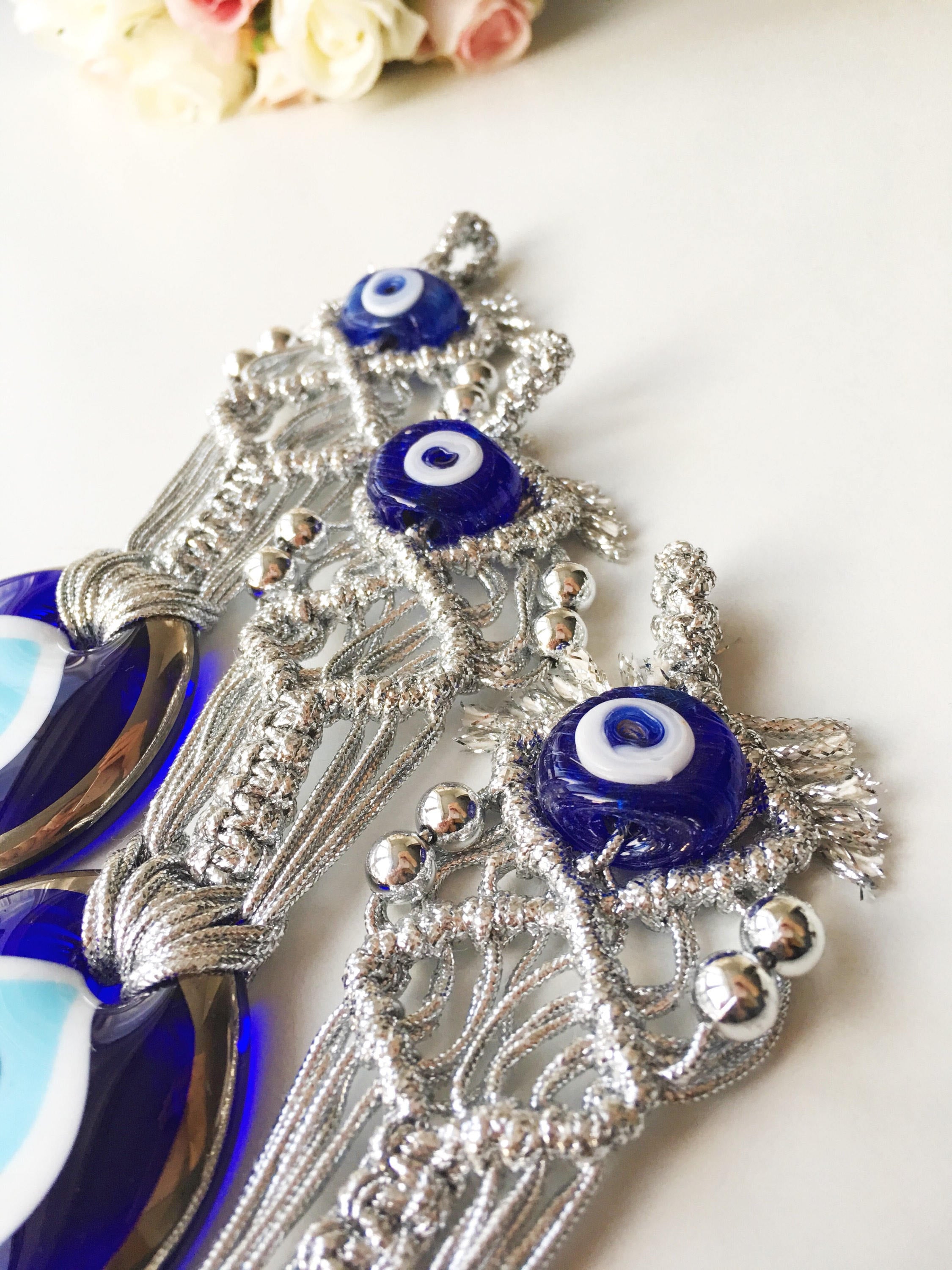 Silver Macrame Evil Eye Charm wall hanging with intricate design and blue evil eye bead.