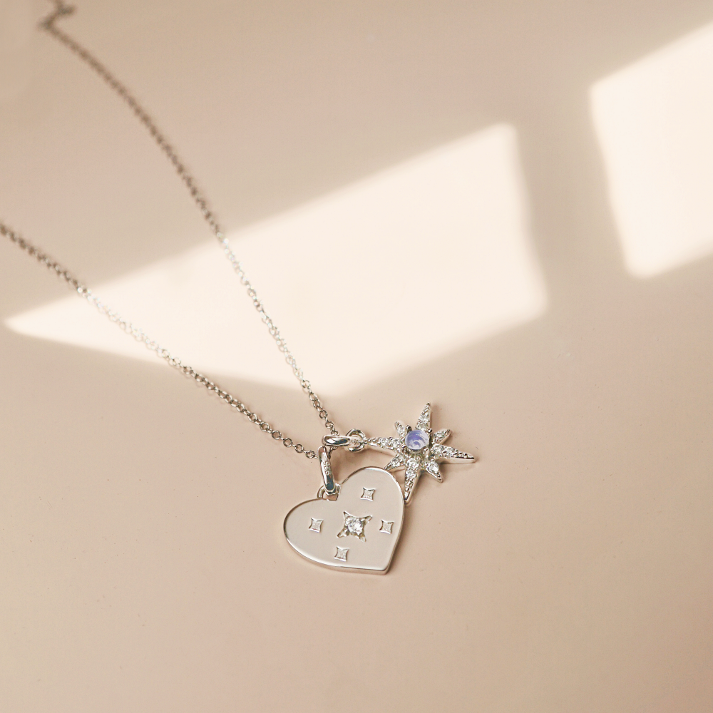 A stunning silver necklace featuring a heart-shaped pendant adorned with delicate stars, symbolizing elegance and self-love.