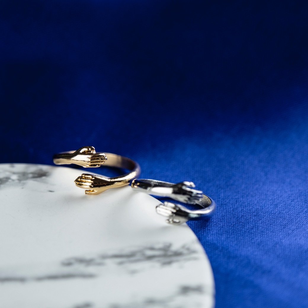 Couple Stackable Love Ring in silver and gold, featuring love hugging hands design, adjustable size for any finger.