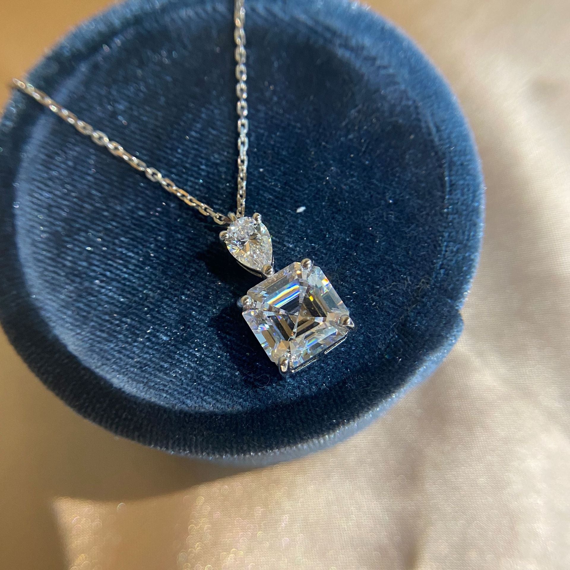 A delicate emerald cut white sapphire necklace made of 925 sterling silver with real white gold filling, featuring an adjustable chain.