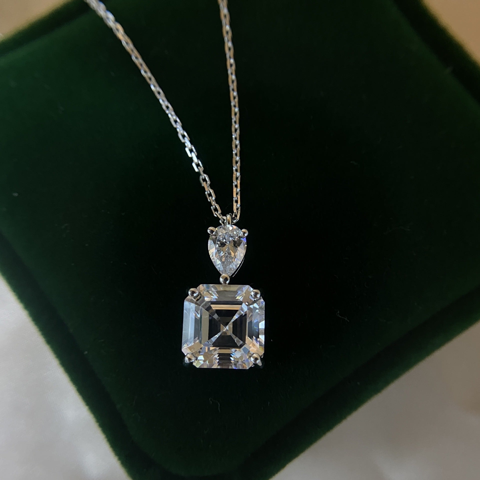 A delicate emerald cut white sapphire necklace made of 925 sterling silver with real white gold filling, featuring an adjustable chain.