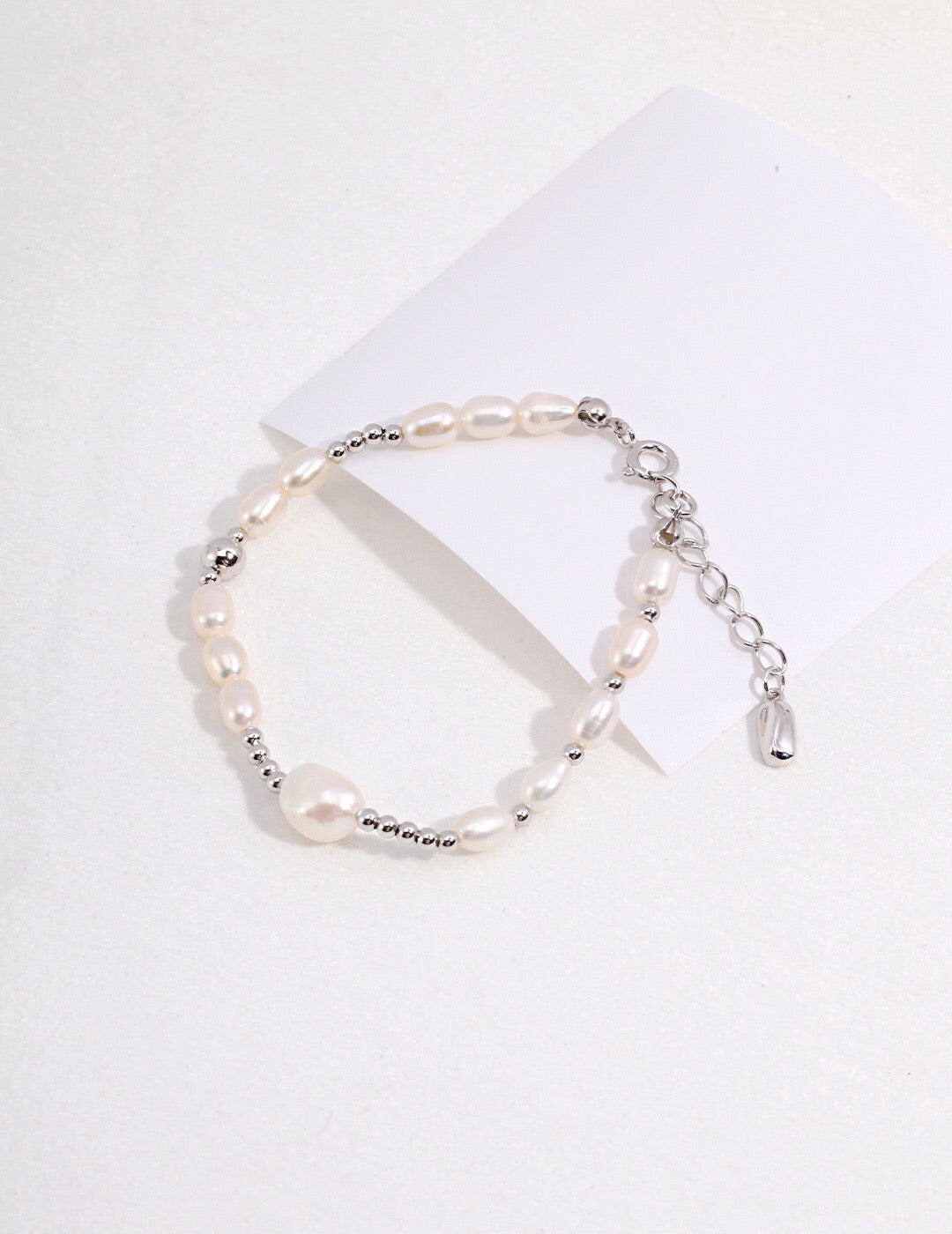 A delicate Simple Elegant Pearl Bracelet featuring natural pearls and gold vermeil, elegantly displayed on a soft fabric background.