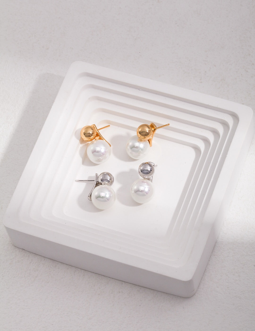 A pair of Simple Elegant Pearl Drop Earrings featuring artificial pearls and gold vermeil, elegantly displayed in a jewelry pouch.