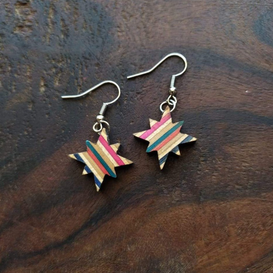 A pair of handcrafted earrings made from recycled skateboard materials, showcasing unique colors and patterns.